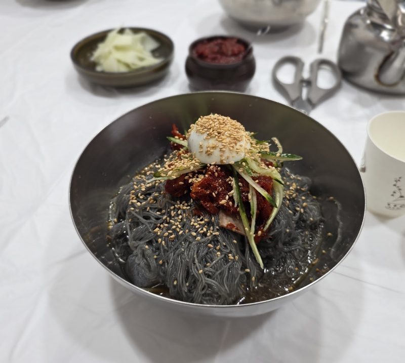 양념한 명태회와 삶은 달걀, 깨를 올린 회냉면 한 그릇